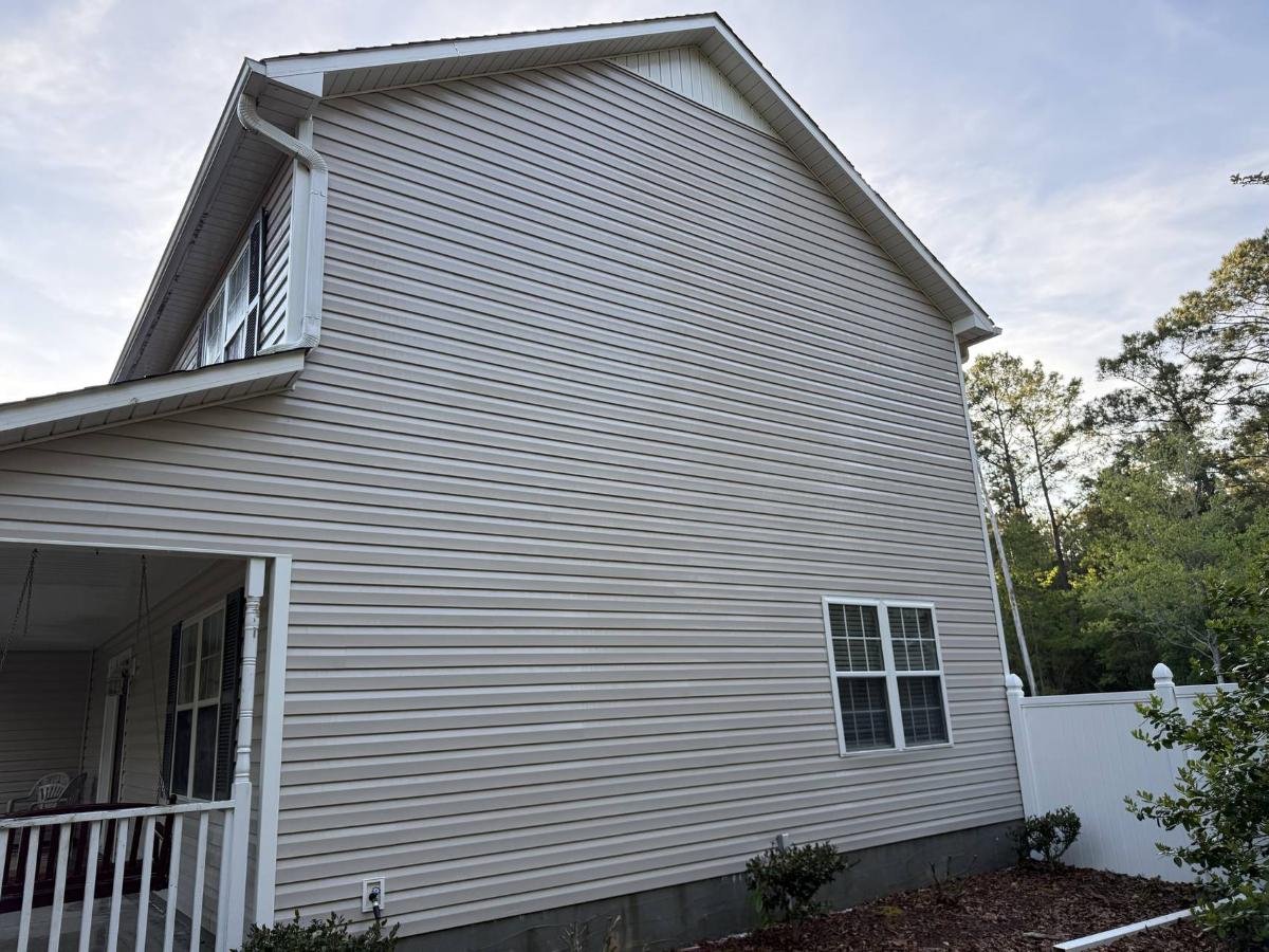 House exterior after pressure washing revealing clean, restored siding free of dirt and stains