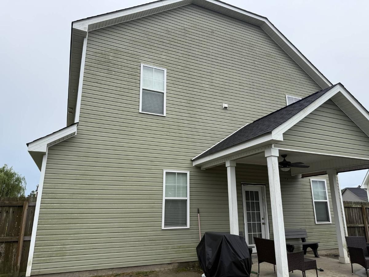 Dirty house exterior before pressure washing with visible stains, mildew, and weathered appearance